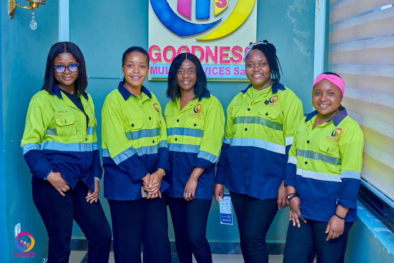 Collaboratrices de Goodness Multi Services Sarl en tenue de sécurité devant le logo de l'entreprise
